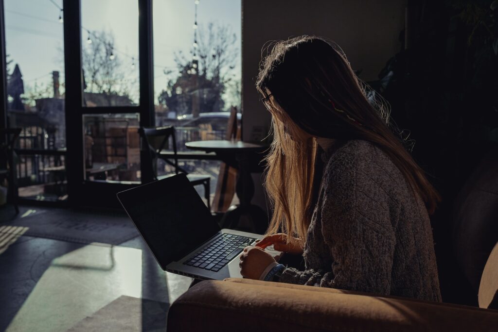 woman in gray sweater using laptop computer, notary services